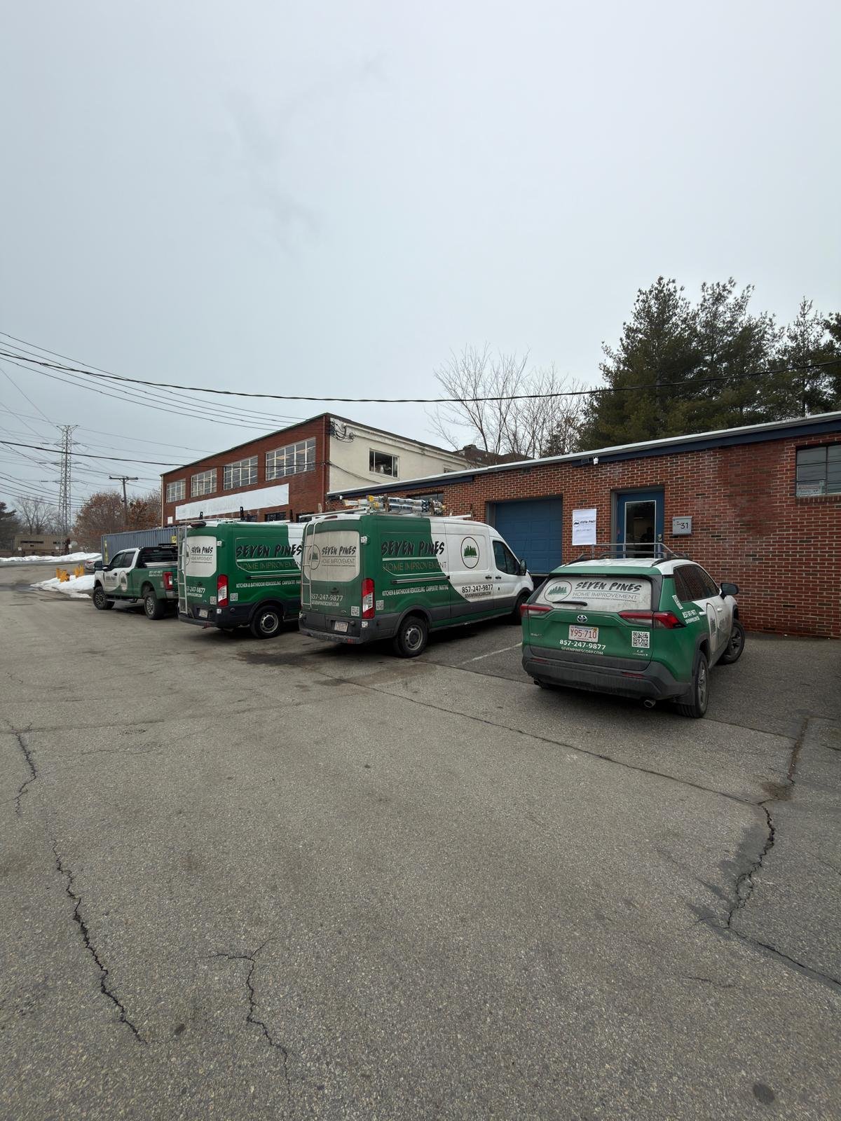 Seven Pines Home Improvement vans, pickup and SUV lined up at the company shop in Shrewsbury, MA