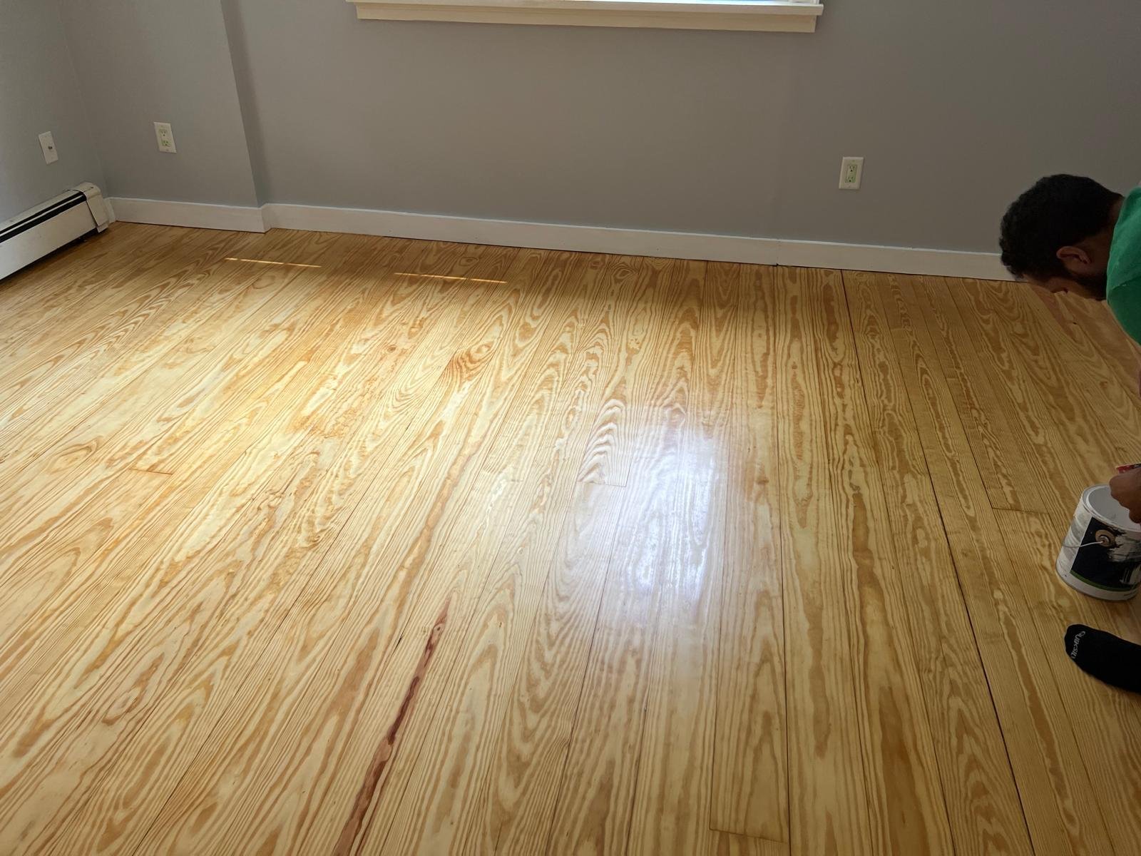 Hardwood floor sanding in progress with a floor sander running across the boards