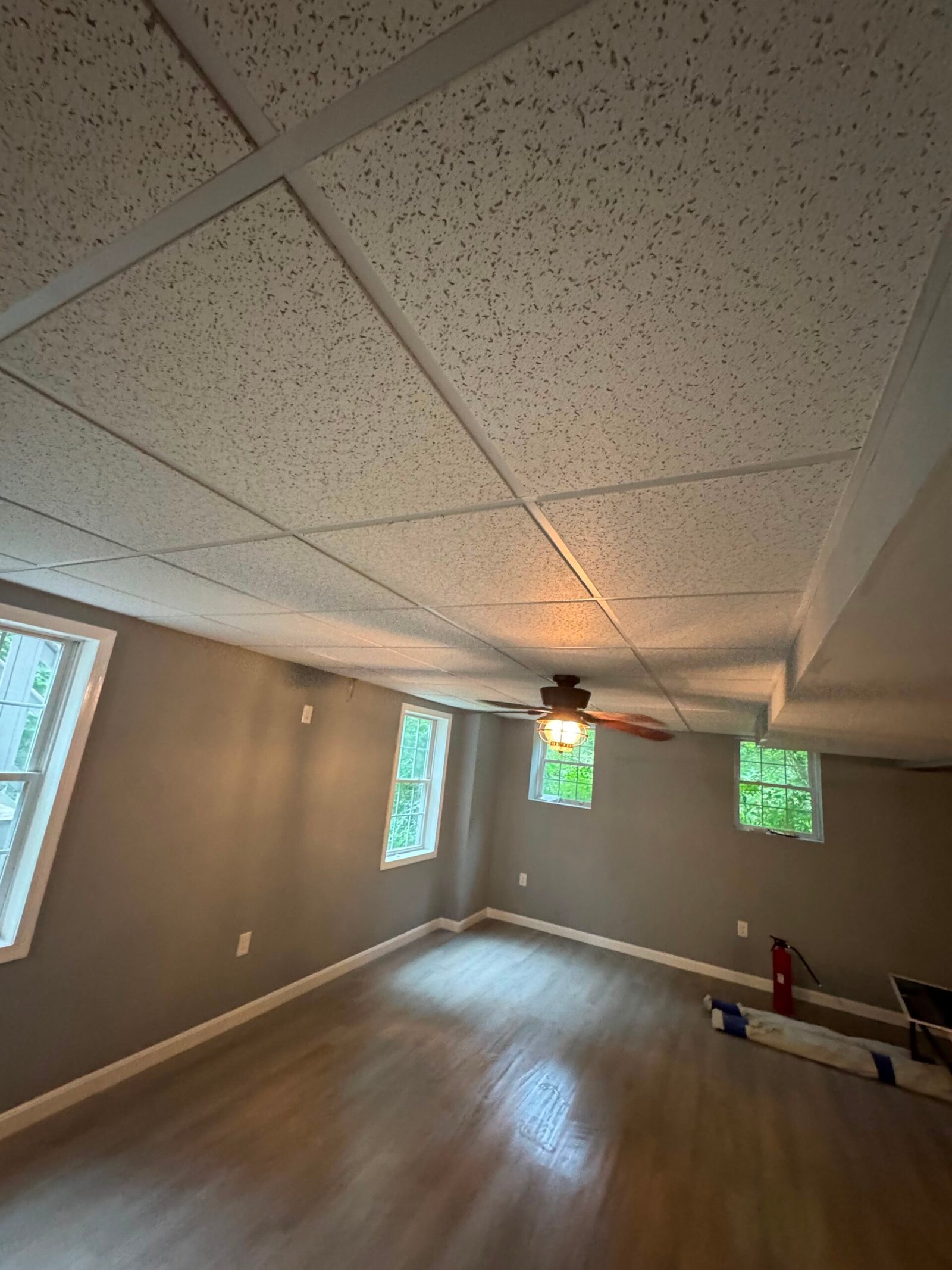 Finished lower-level room with new flooring and painted walls in Natick, MA