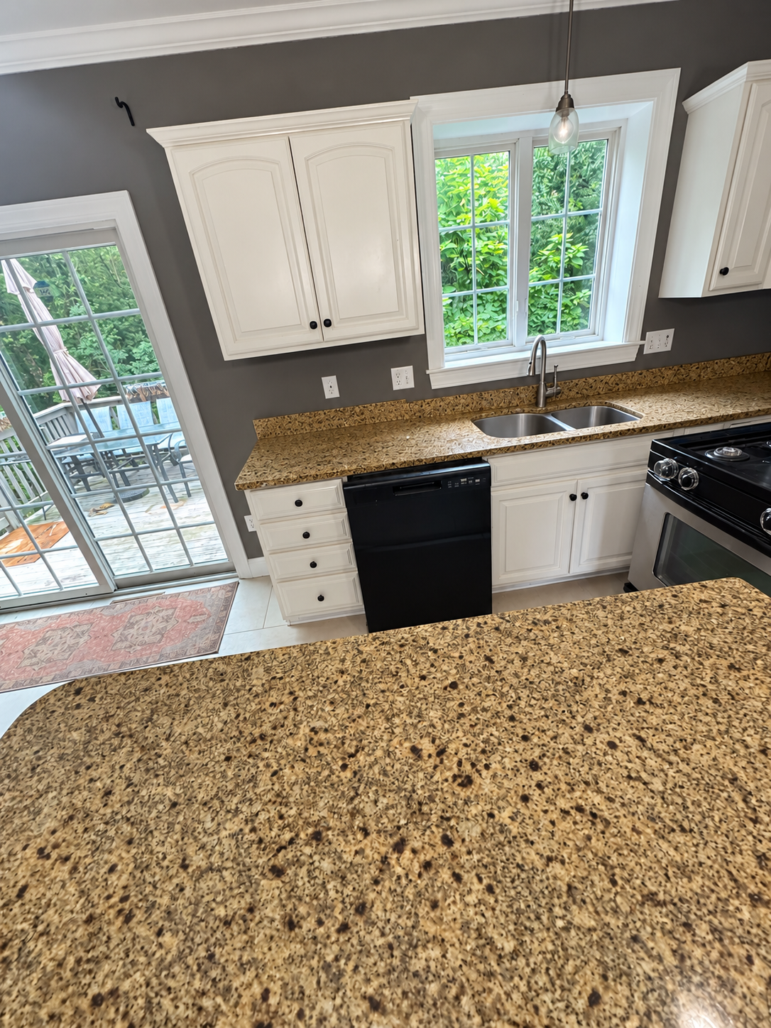 Natick, MA kitchen with cream cabinetry, granite counters and a garden view