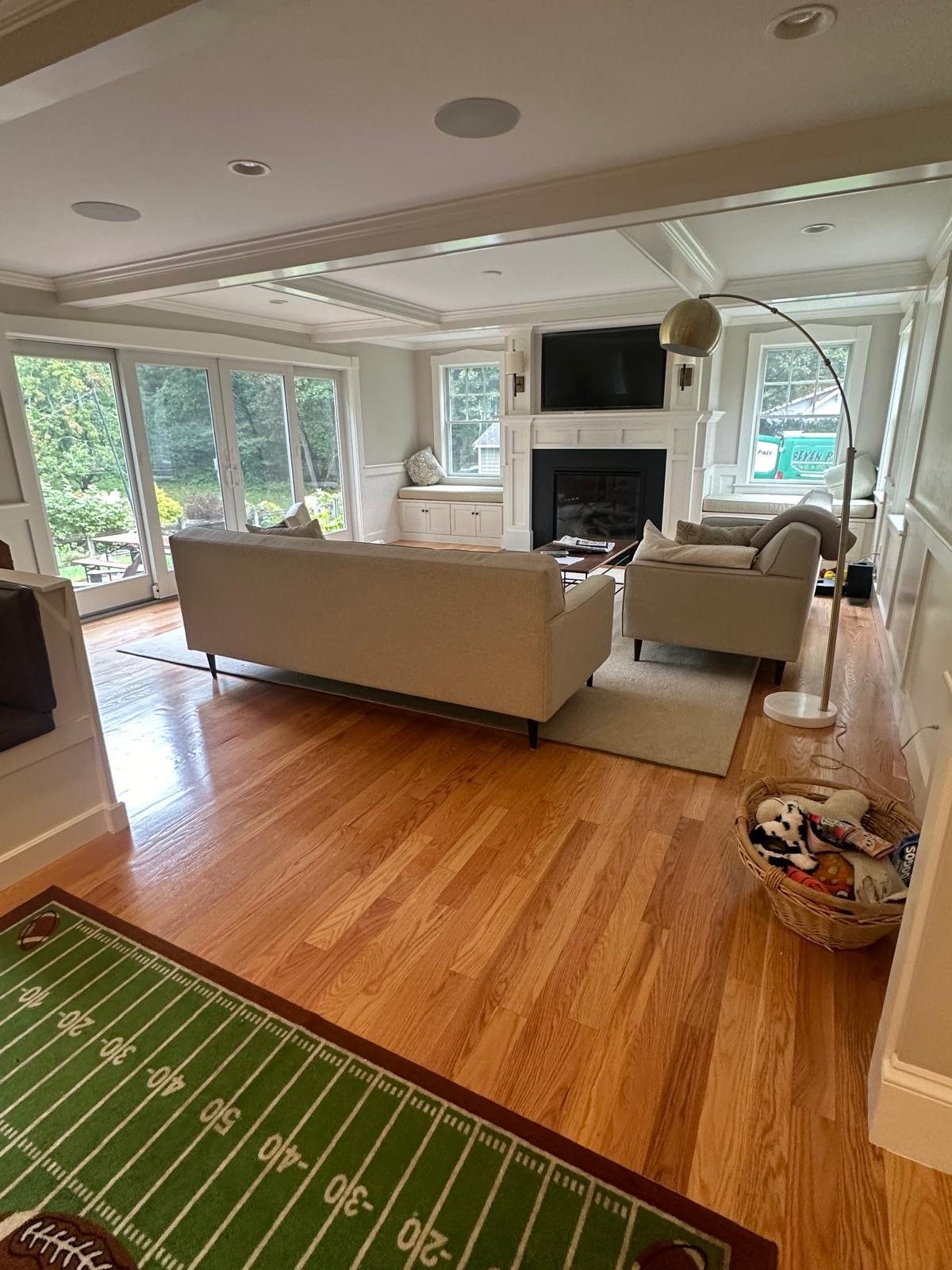 Family room with a coffered ceiling, fireplace millwork and window seats in Newton, MA