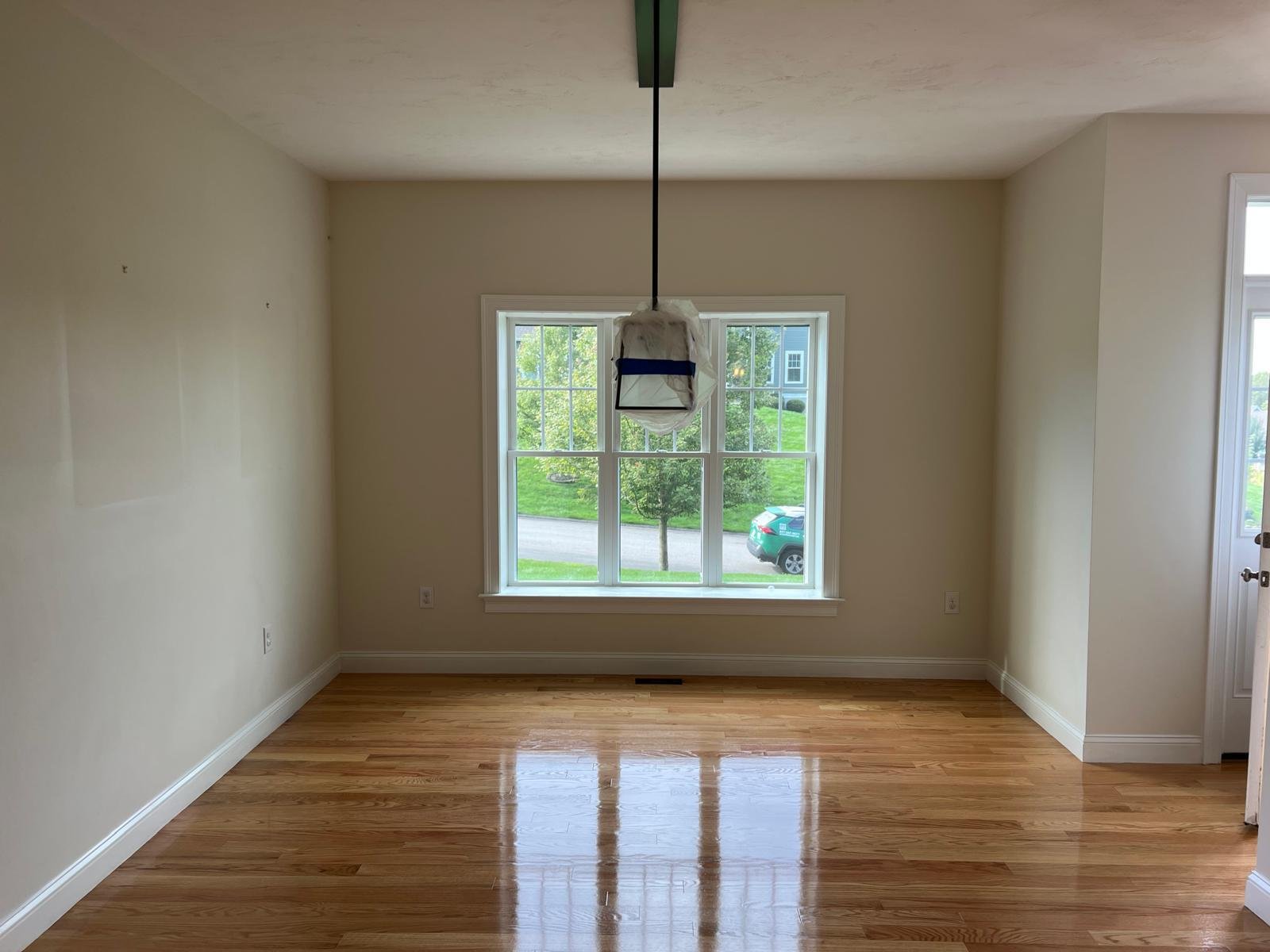 Refinished red oak floor with a clear gloss finish in a freshly painted dining room