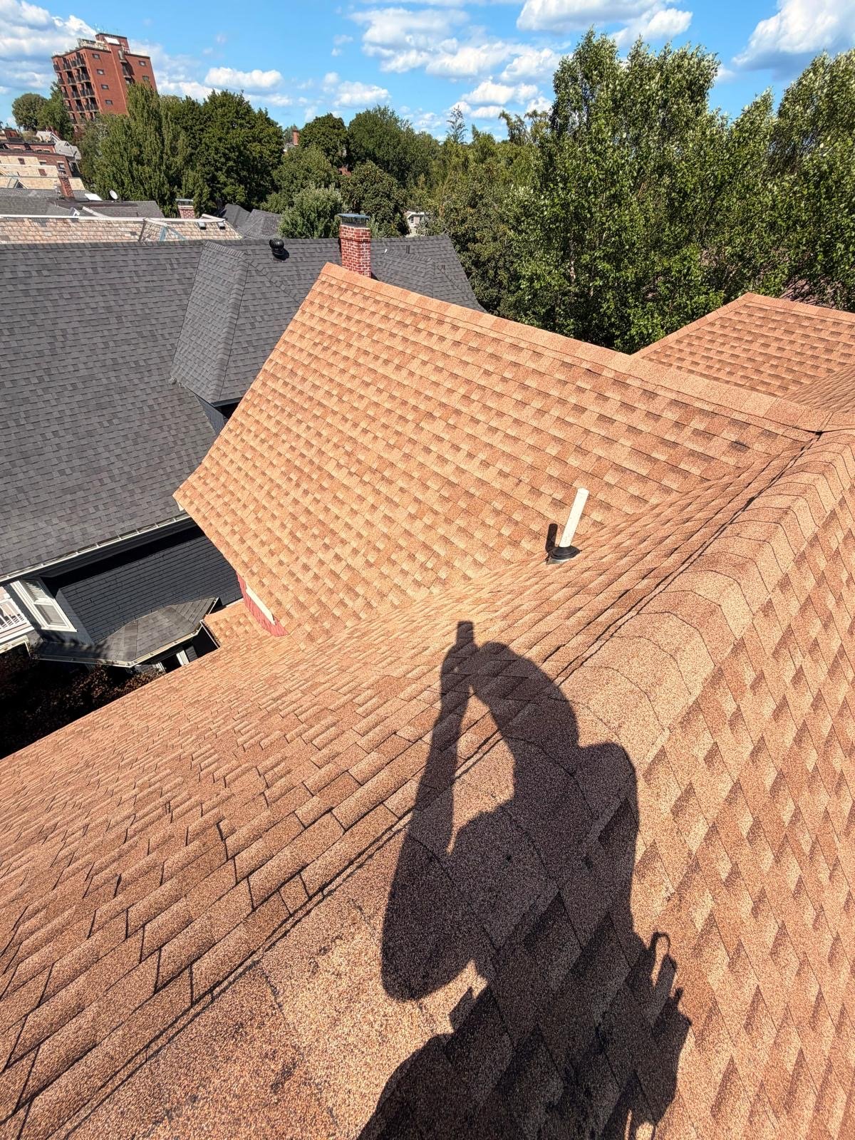 Newly shingled valley and ridge over the rear elevation of a Shrewsbury, MA home