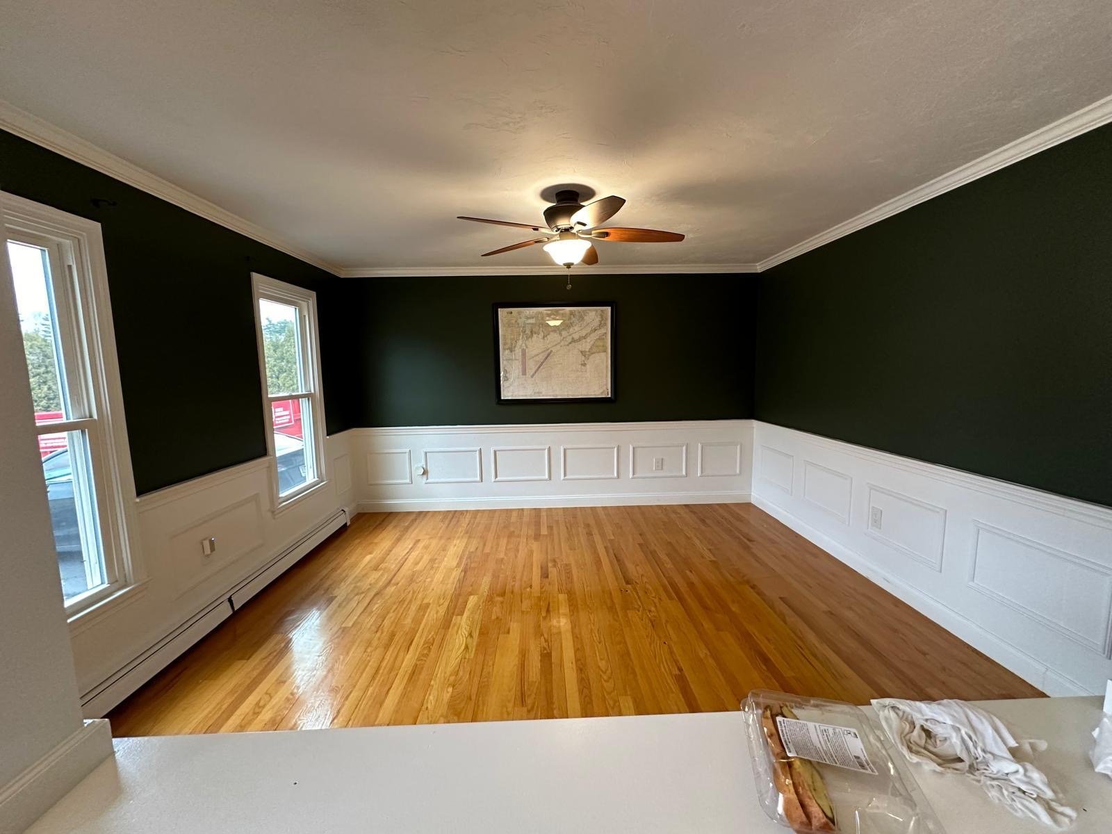 Dining room with white raised-panel wainscoting, crown moulding and a refinished oak floor