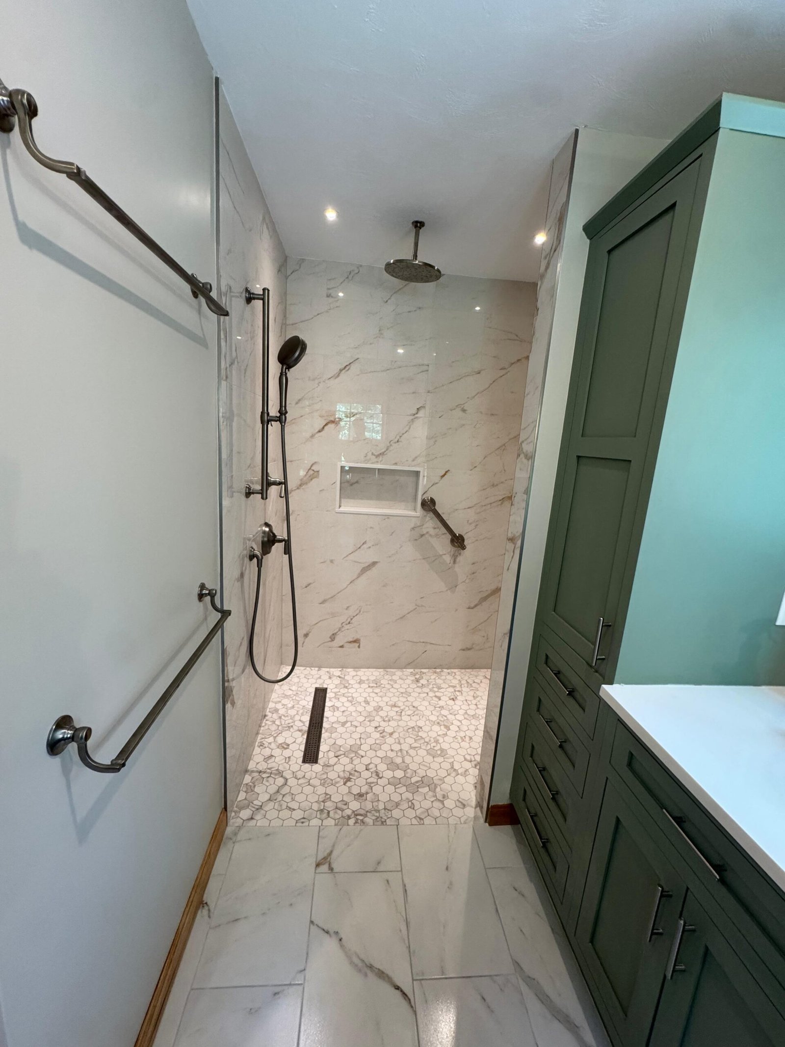 Tiled walk-in shower with a rain head and hex mosaic floor in Weston, MA